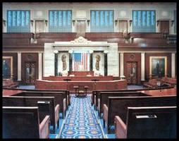 The chamber of the United States House of Representatives is located in the south wing of the Capitol building, in Washington, D.C. This photograph shows a rare glimpse of the four vote tallying boards (the blackish squares across the top), which display each member's name and vote while votes are in progress. The screens are notably used by Congressional leaders to identify which members are voting against party lines.